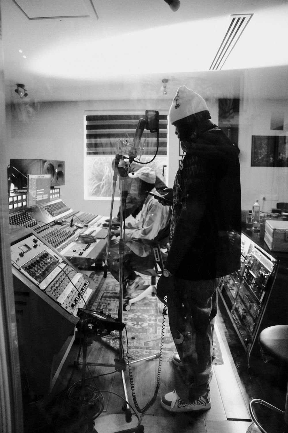 a man standing in front of a microphone in a recording studio