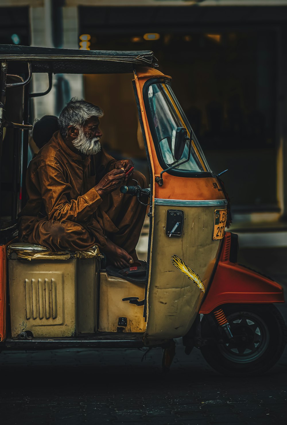 an old man sitting in the back of a small car