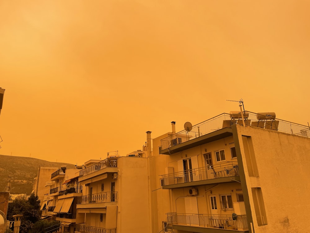 a yellow sky with a few buildings in the foreground