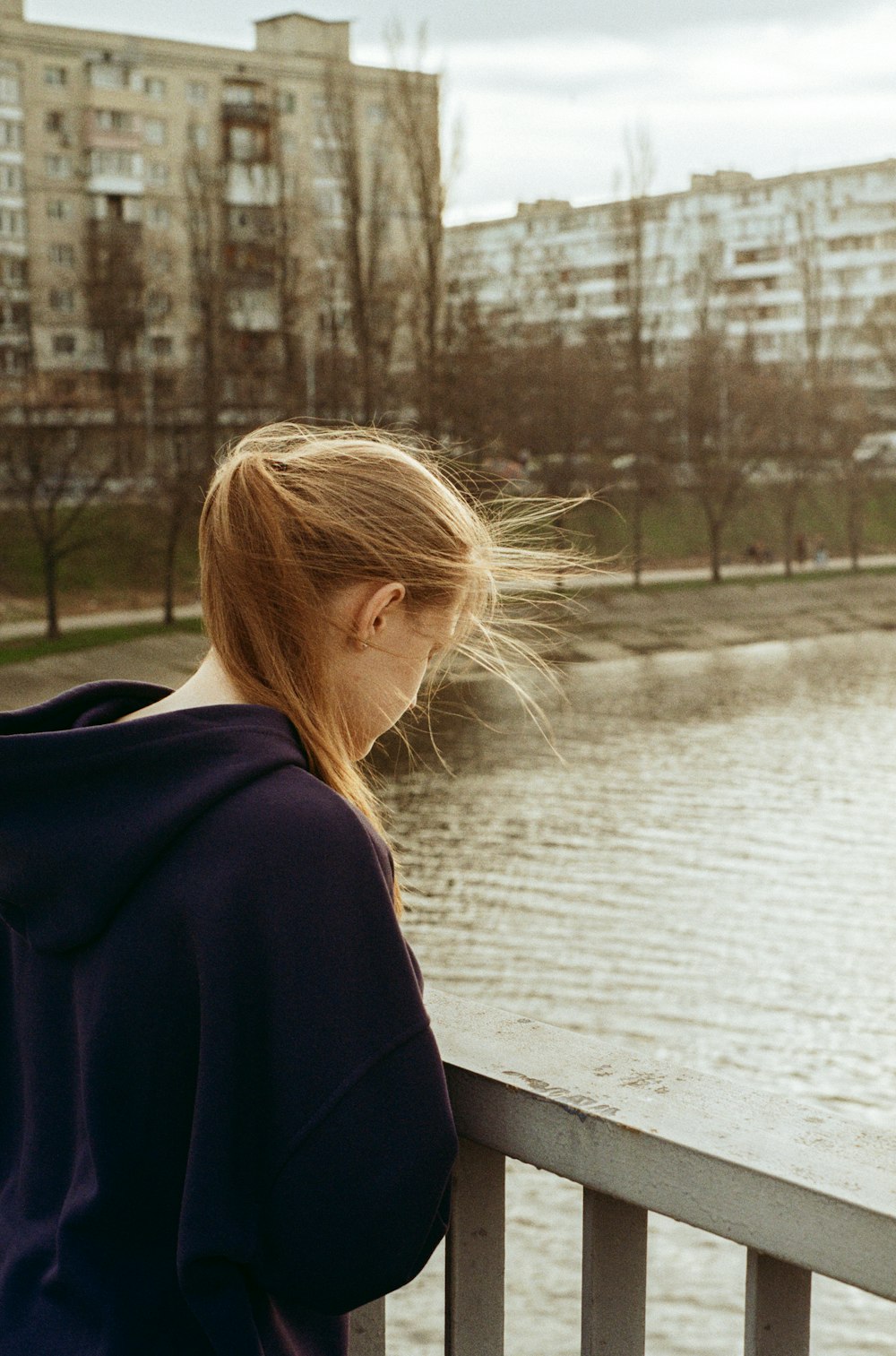 a woman standing on a bridge next to a body of water