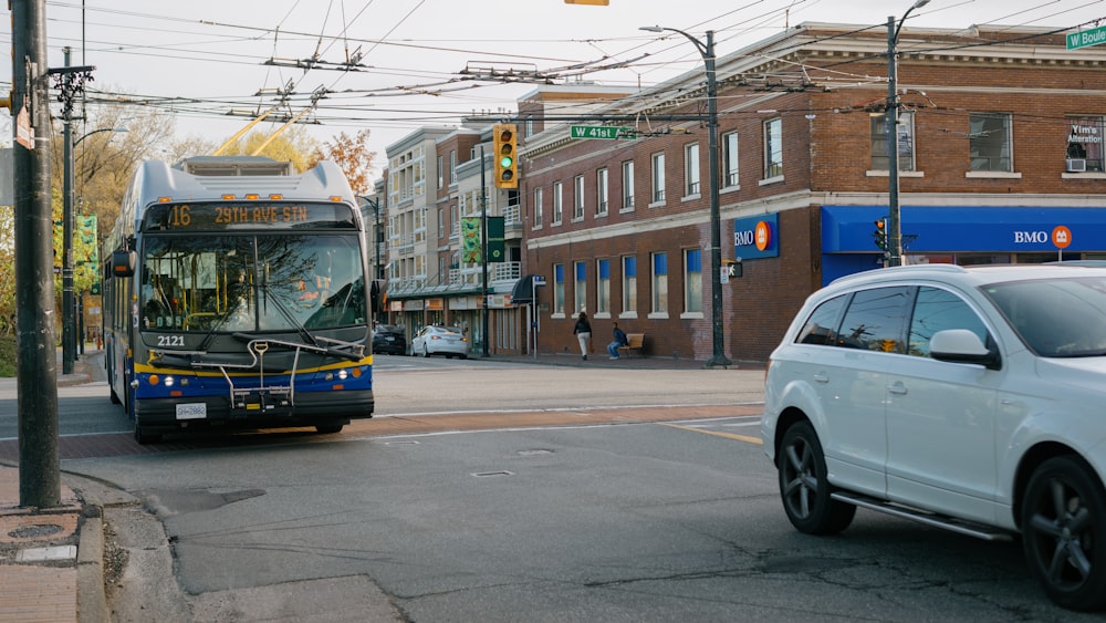 a bus driving down a street next to a white car