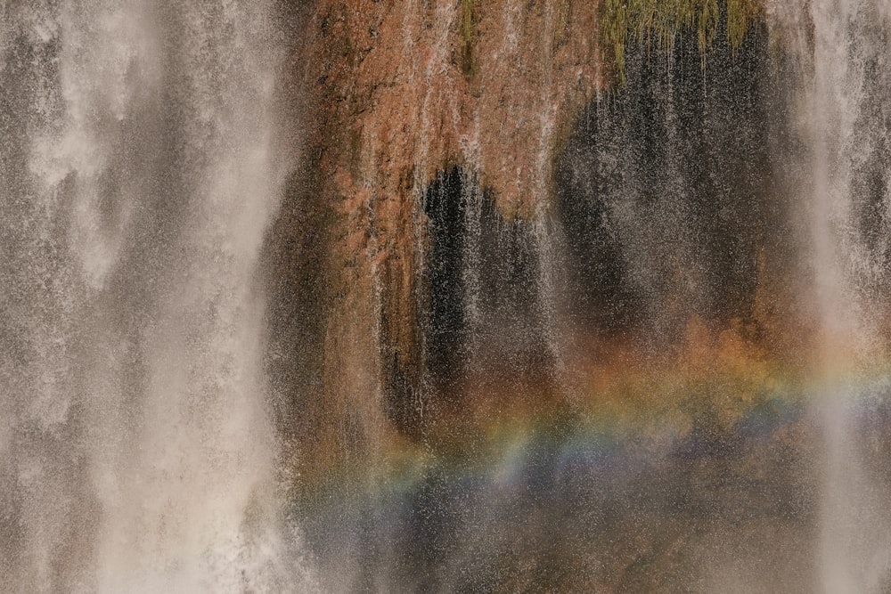 a waterfall with a rainbow in the middle of it