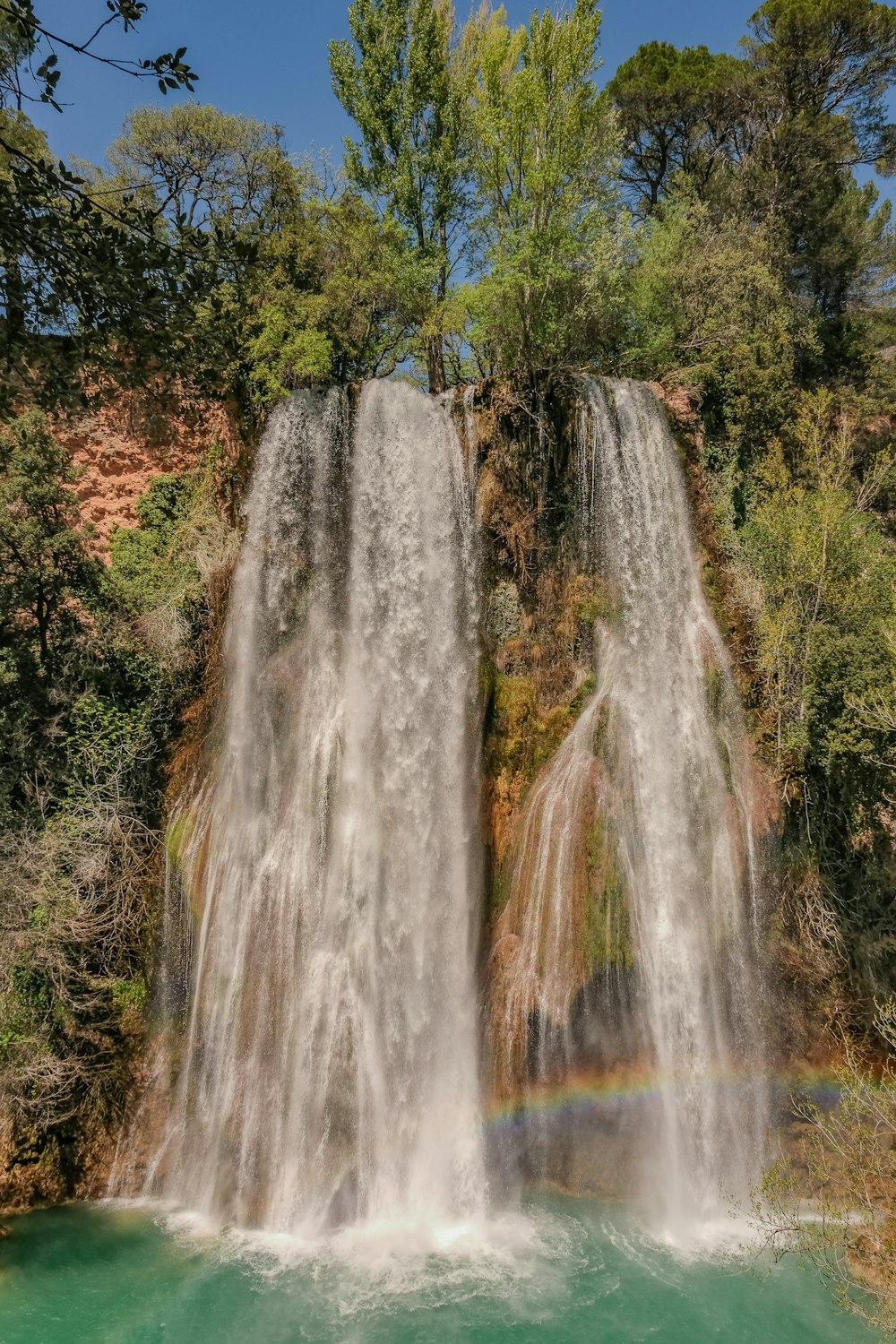 a waterfall with a rainbow in the middle of it