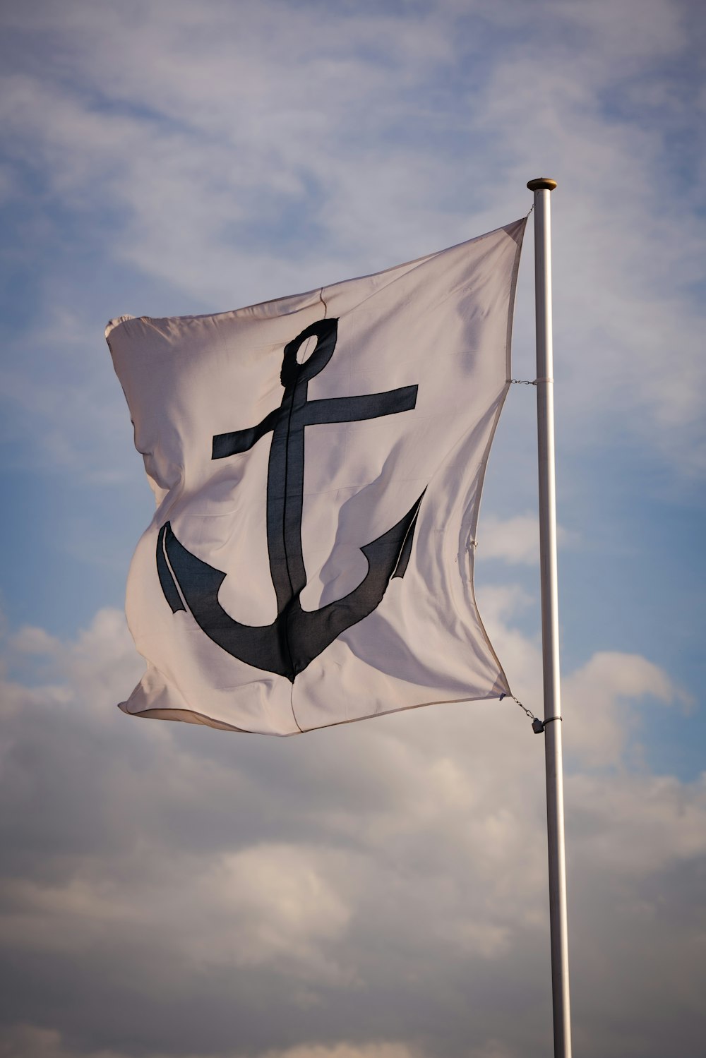 a white and black flag with an anchor on it