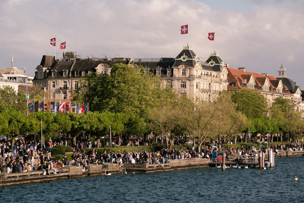 a group of people standing on the side of a river