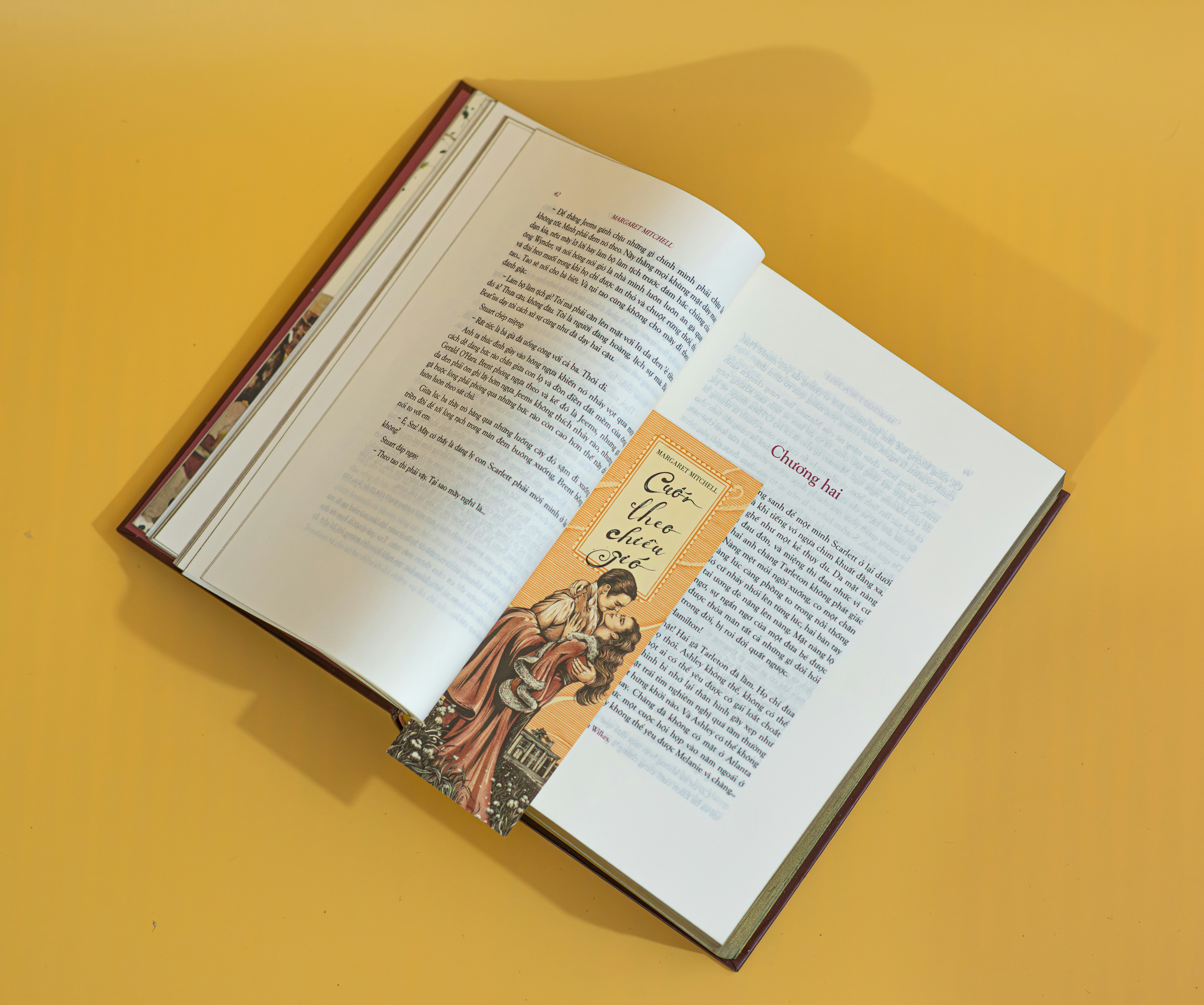 an open book on a table with a yellow background