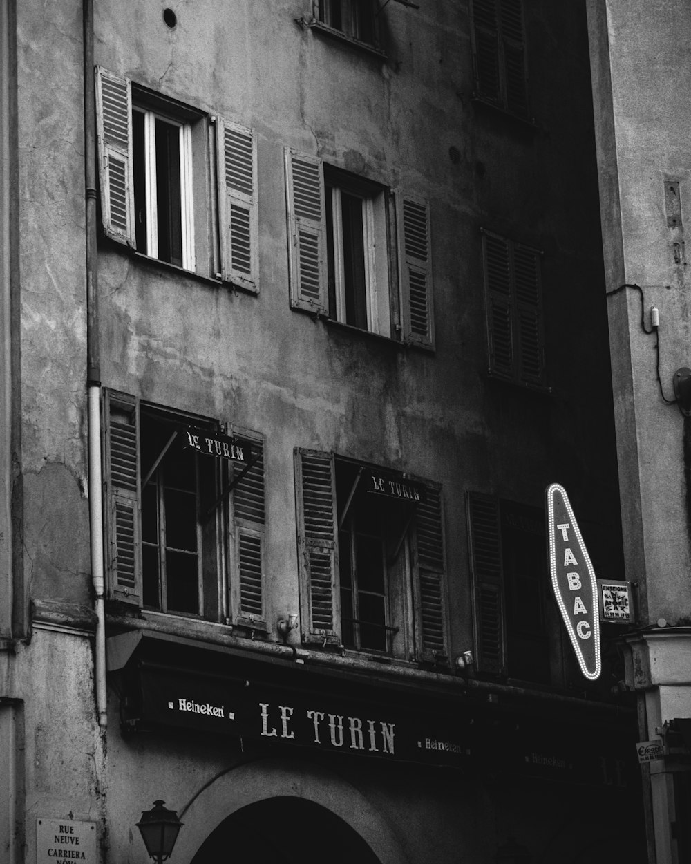 a black and white photo of a building with shutters