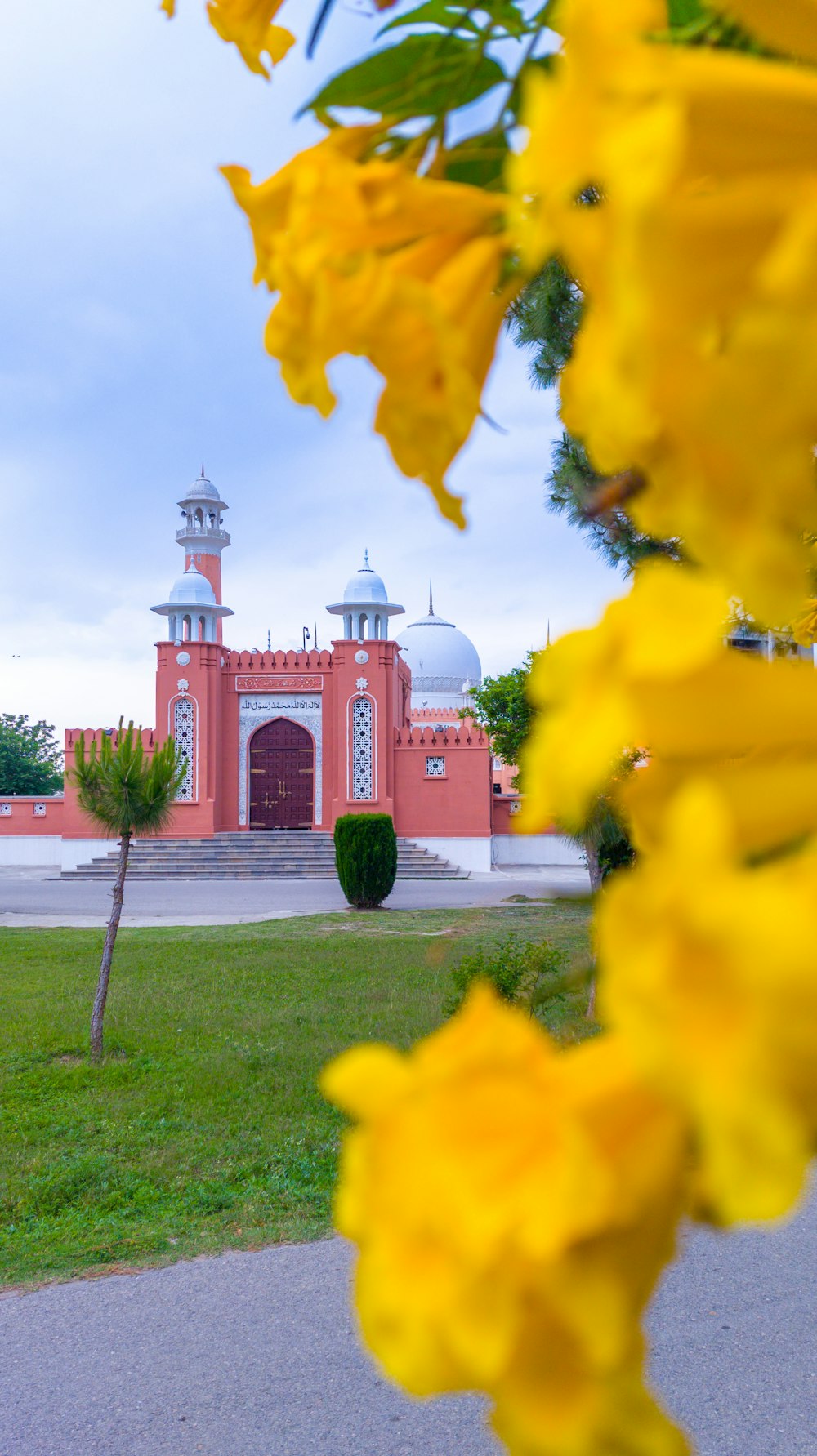 a red building with a white dome and a green lawn