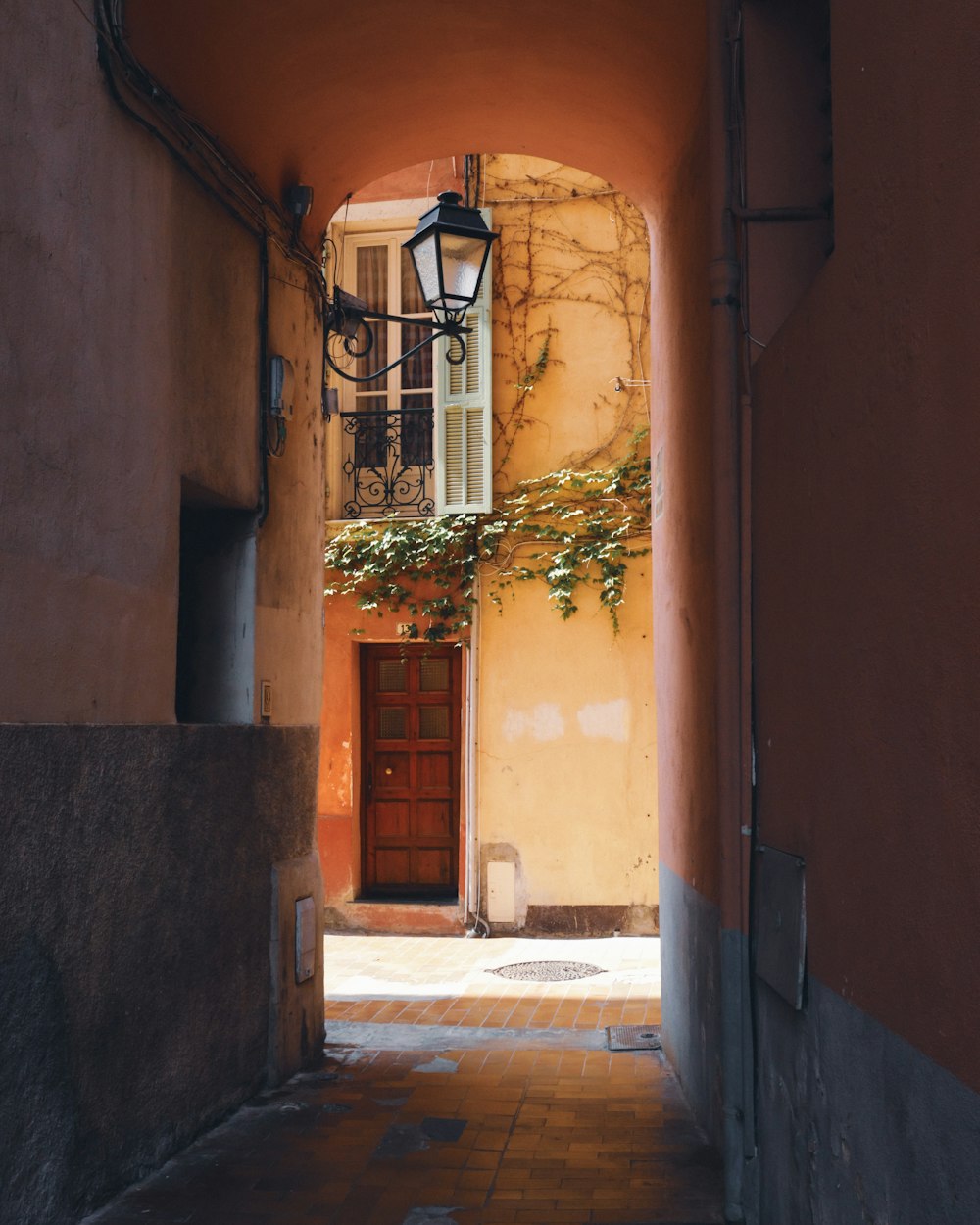an alley way with a lamp and a door
