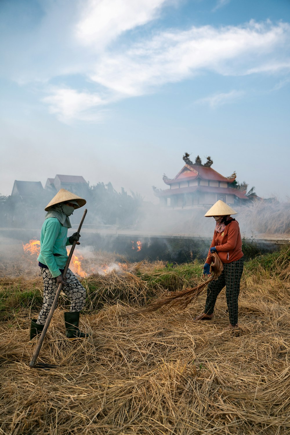 a couple of women standing on top of a dry grass field