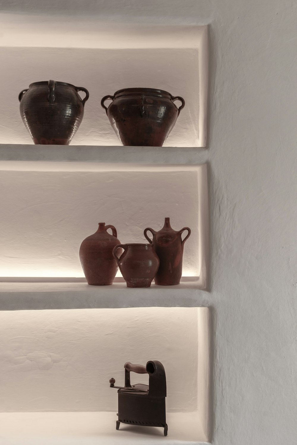 a shelf filled with vases and a miniature chair