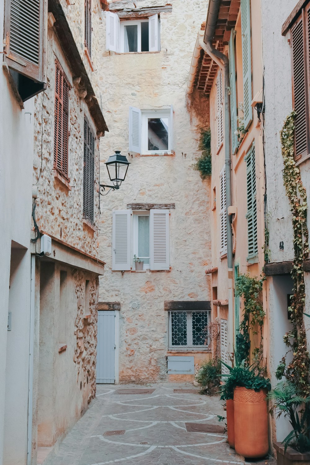 a narrow alley way with a lamp on the side