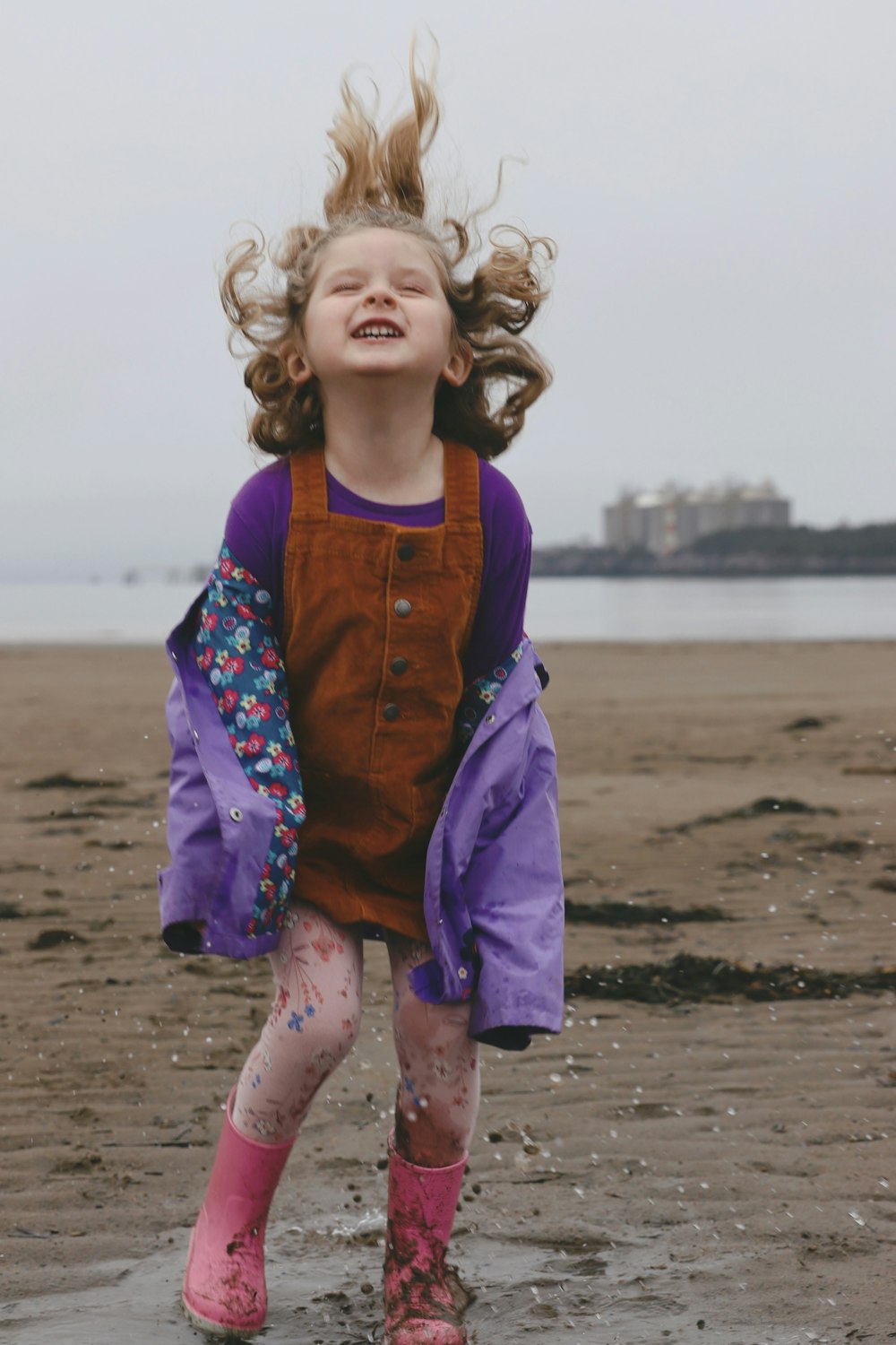 a little girl that is standing in the sand