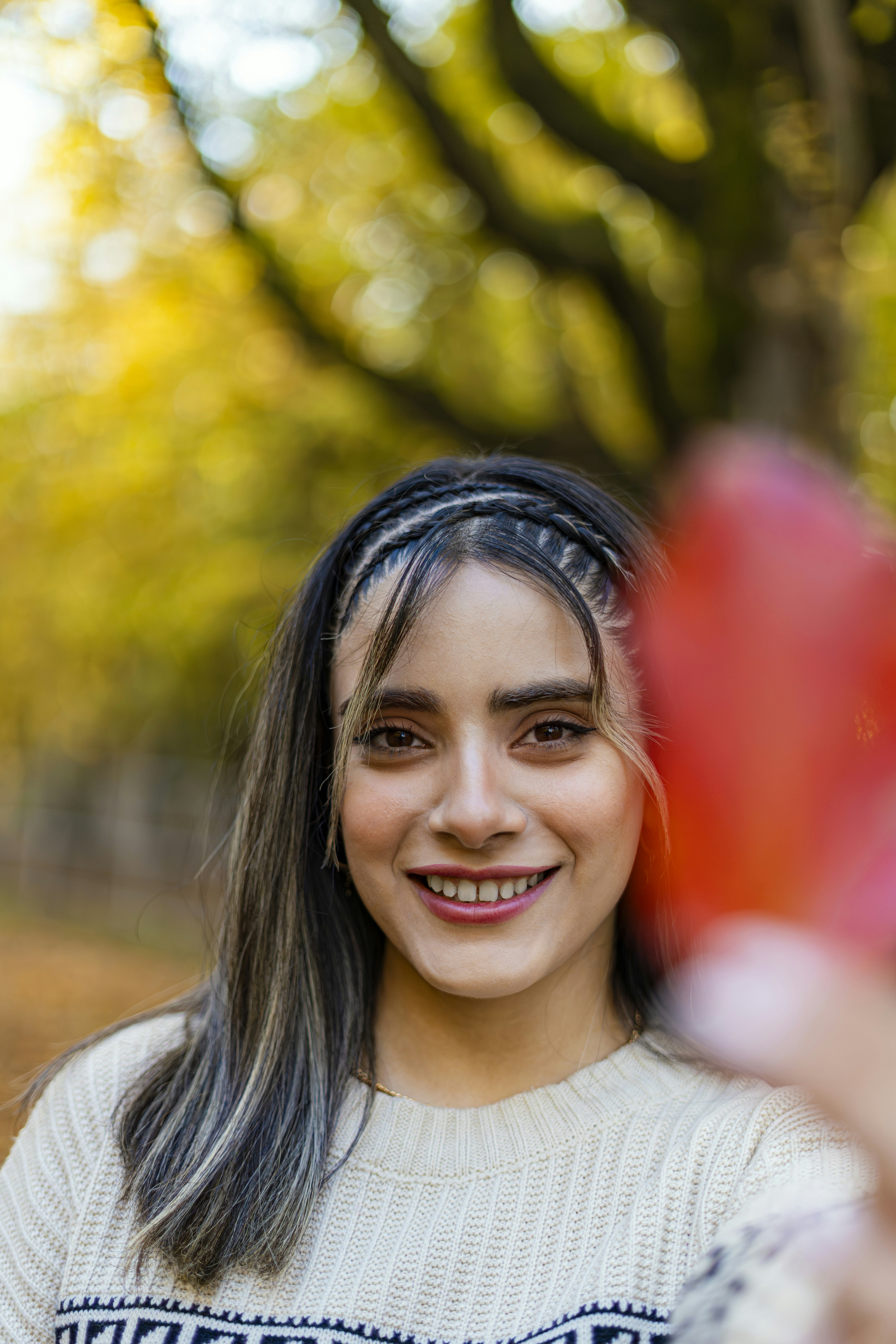 a woman holding a red frisbee in a park