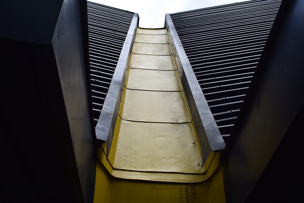 a very tall building with a yellow ramp going up it's side
