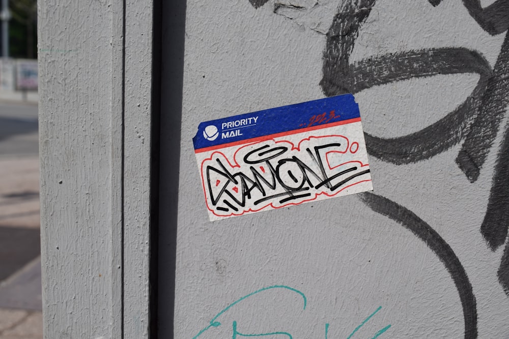 a sticker on the side of a wall with graffiti
