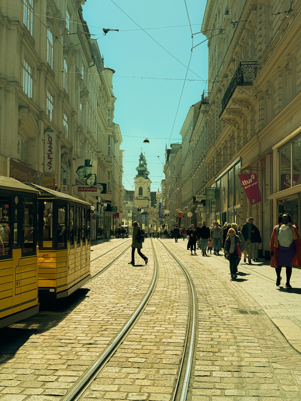 Ein gelber Trolley auf einer Straße in der Stadt mit Menschen, die herumlaufen