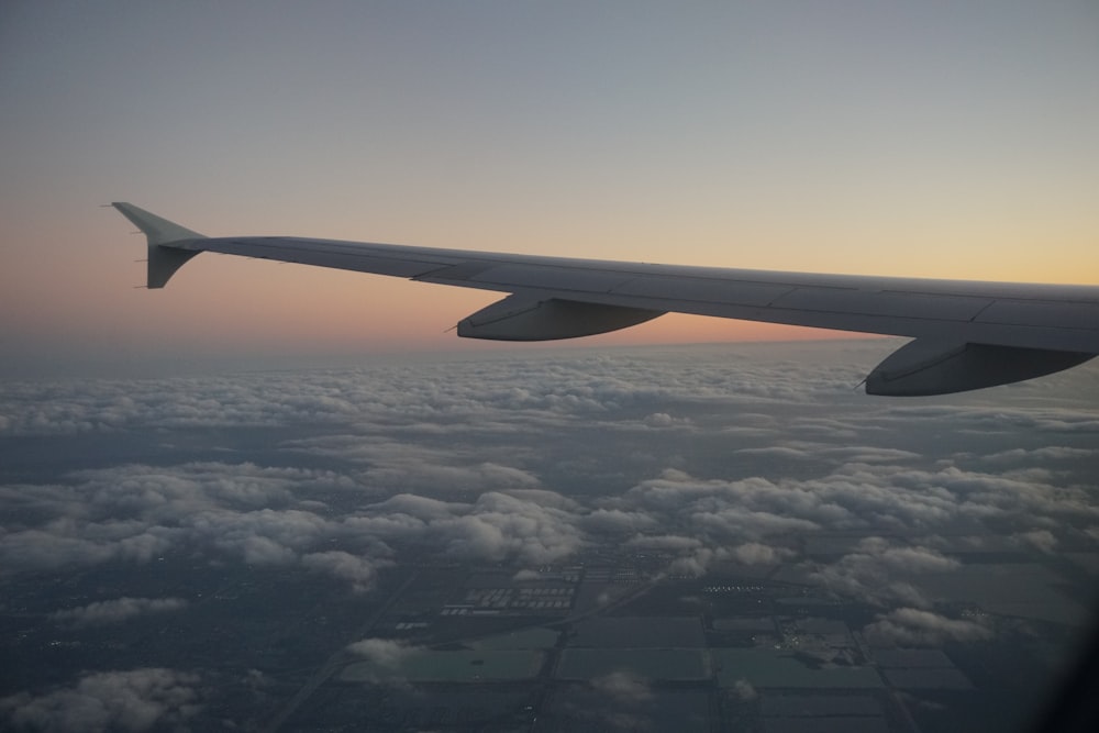 the wing of an airplane flying above the clouds