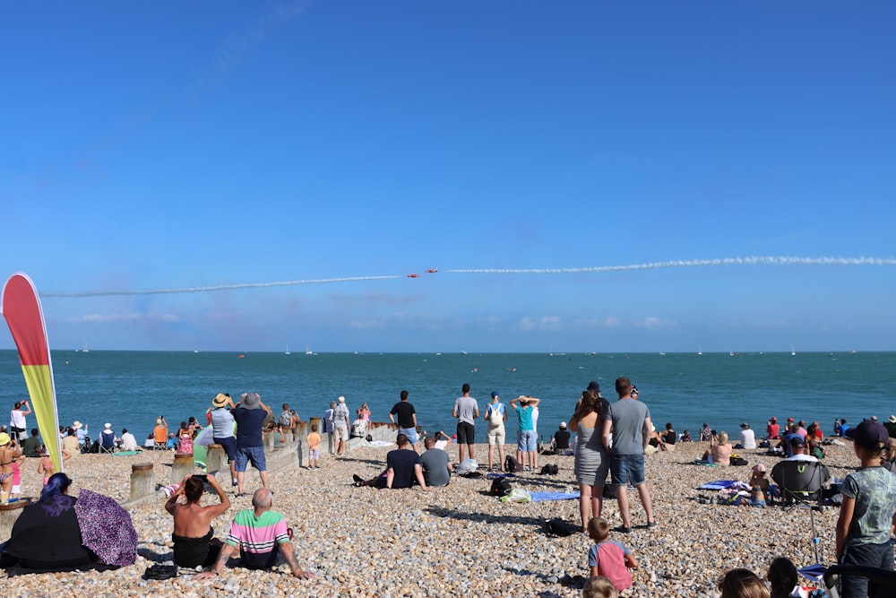 a group of people sitting on top of a sandy beach