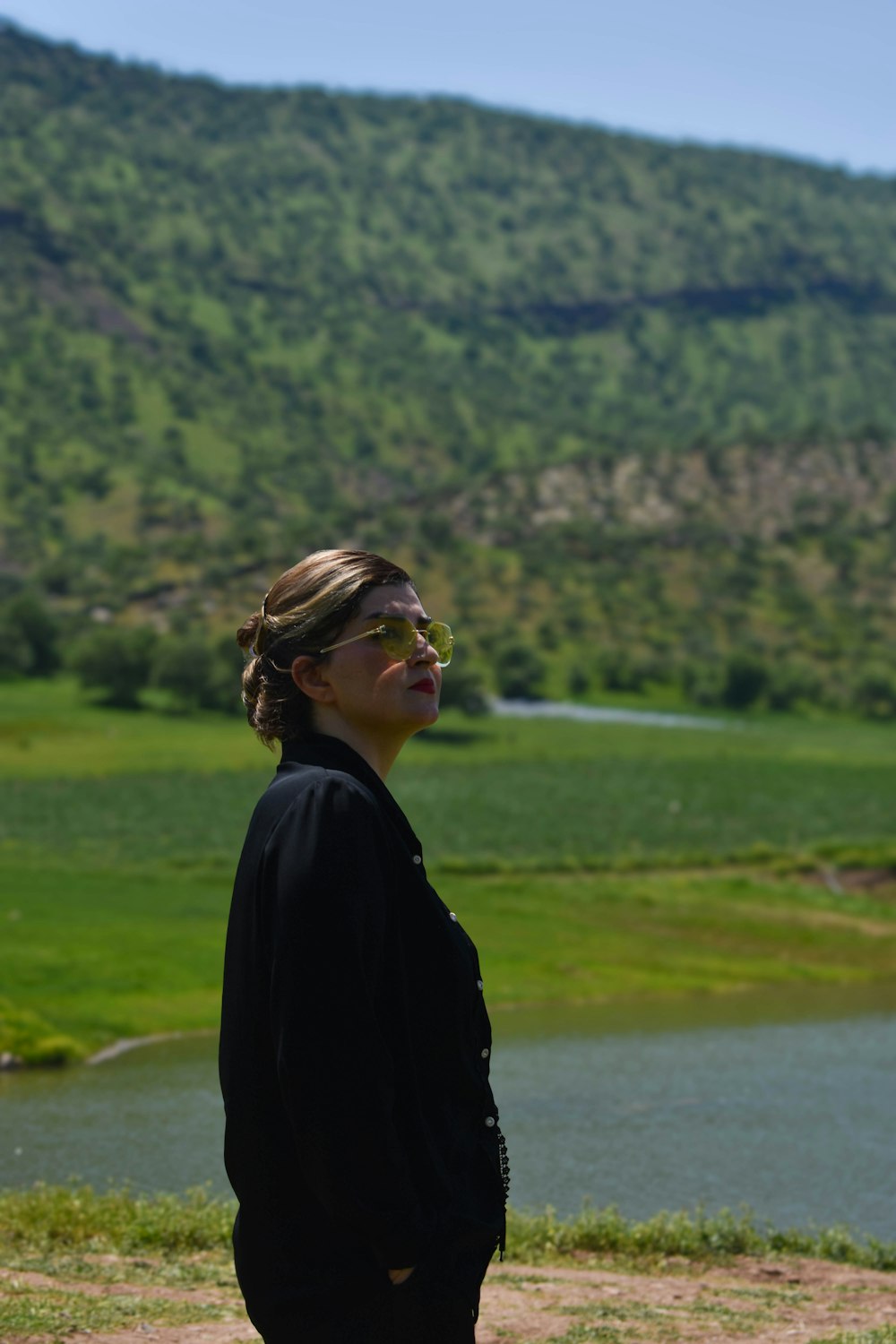 a woman standing in front of a body of water