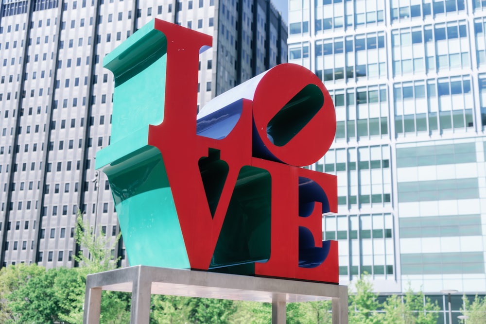 a large love sculpture in front of a large building