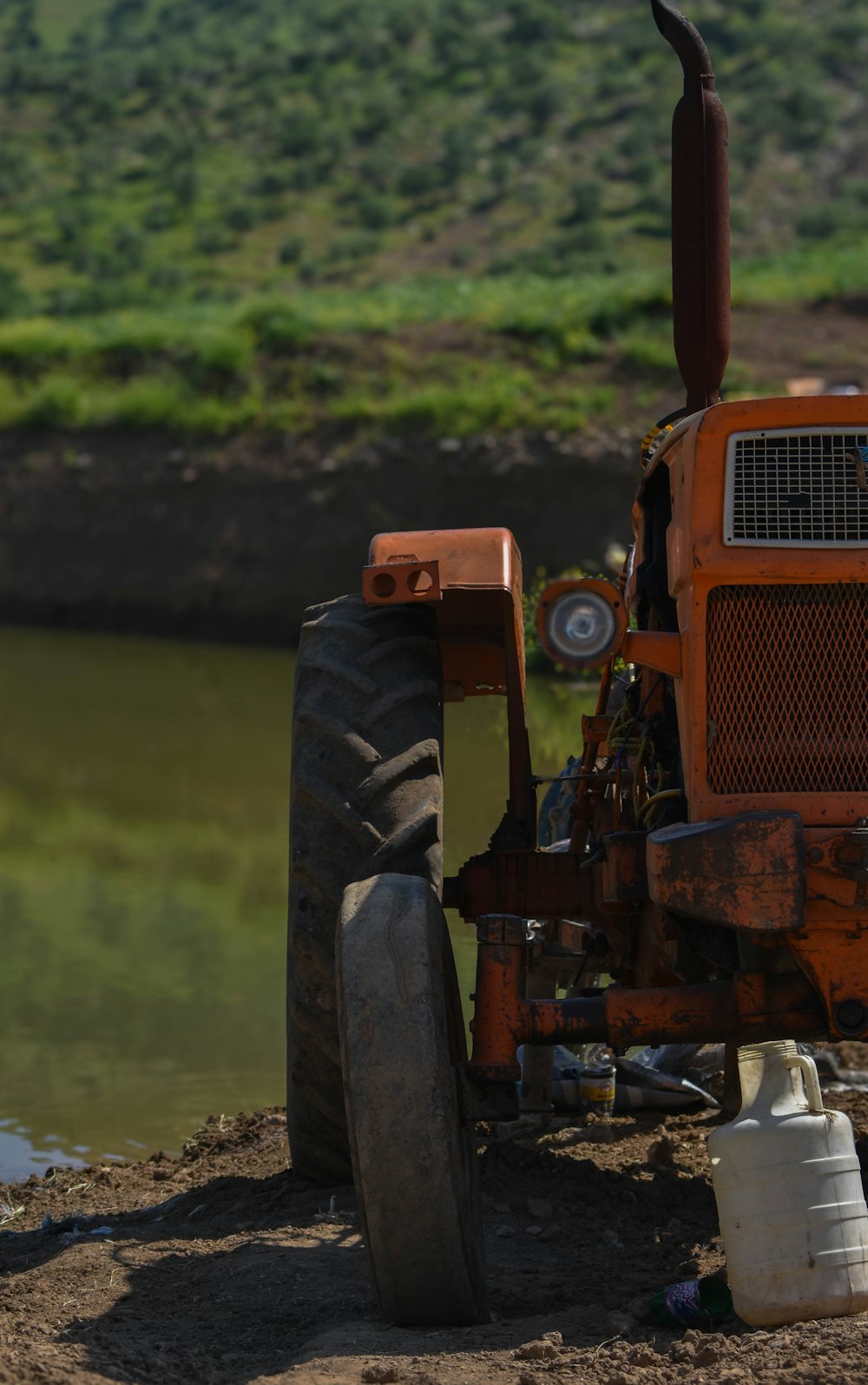 a tractor parked next to a body of water