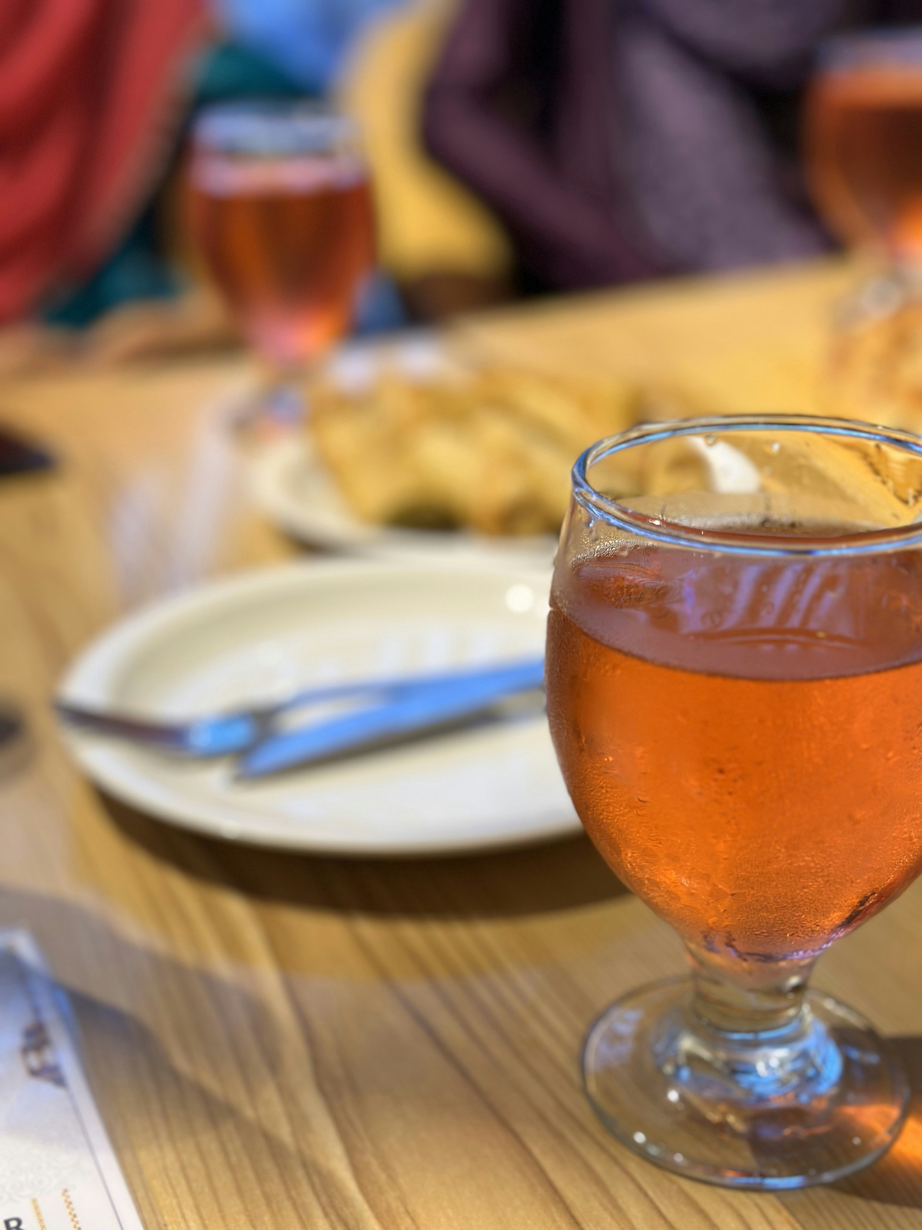 a glass of wine sitting on top of a wooden table