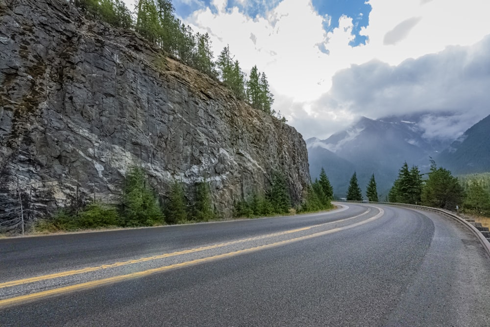 a curved road with a mountain in the background