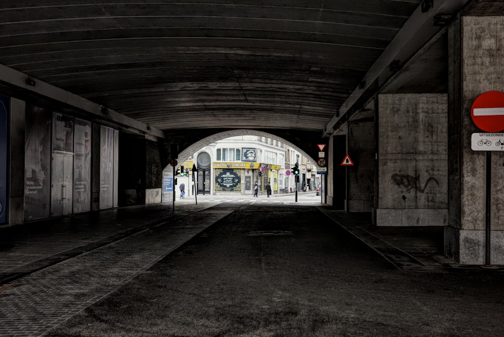 a train station with a train coming out of the tunnel