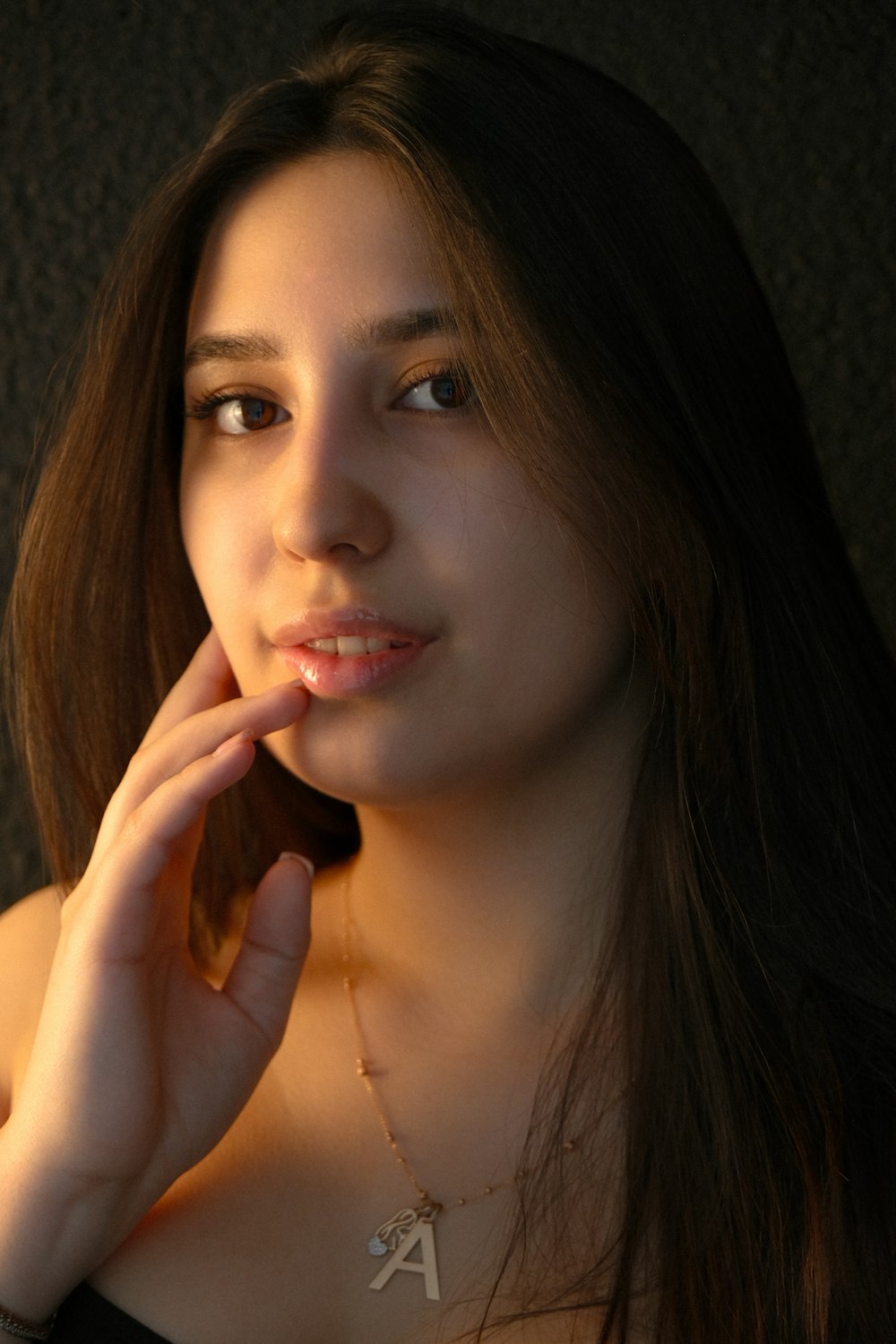 a woman is posing for a picture with her hand on her chin