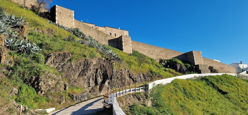 a person walking up a steep hill next to a castle