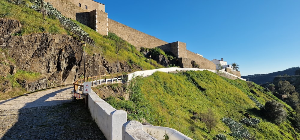 a stone walkway leading up to a castle on a hill