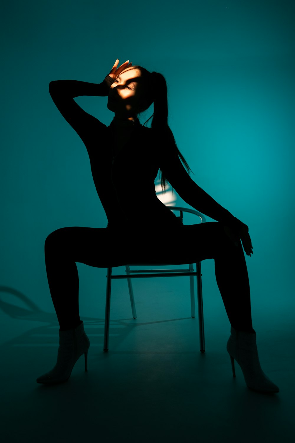 a woman sitting on a chair in a dark room