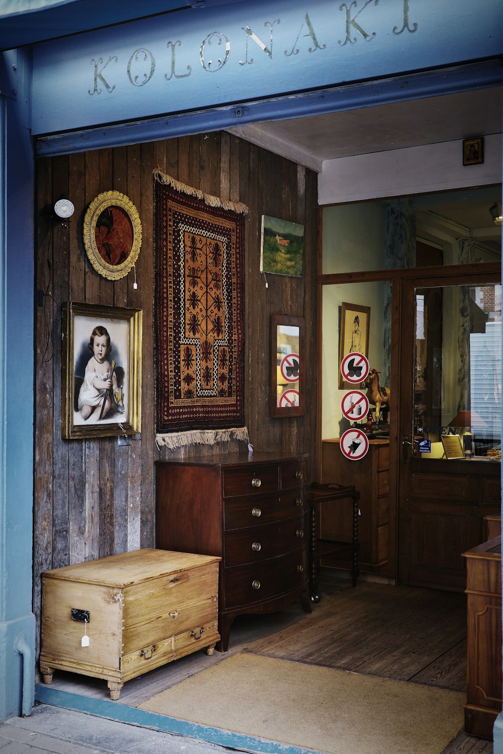 a room with a dresser, chest of drawers and pictures on the wall