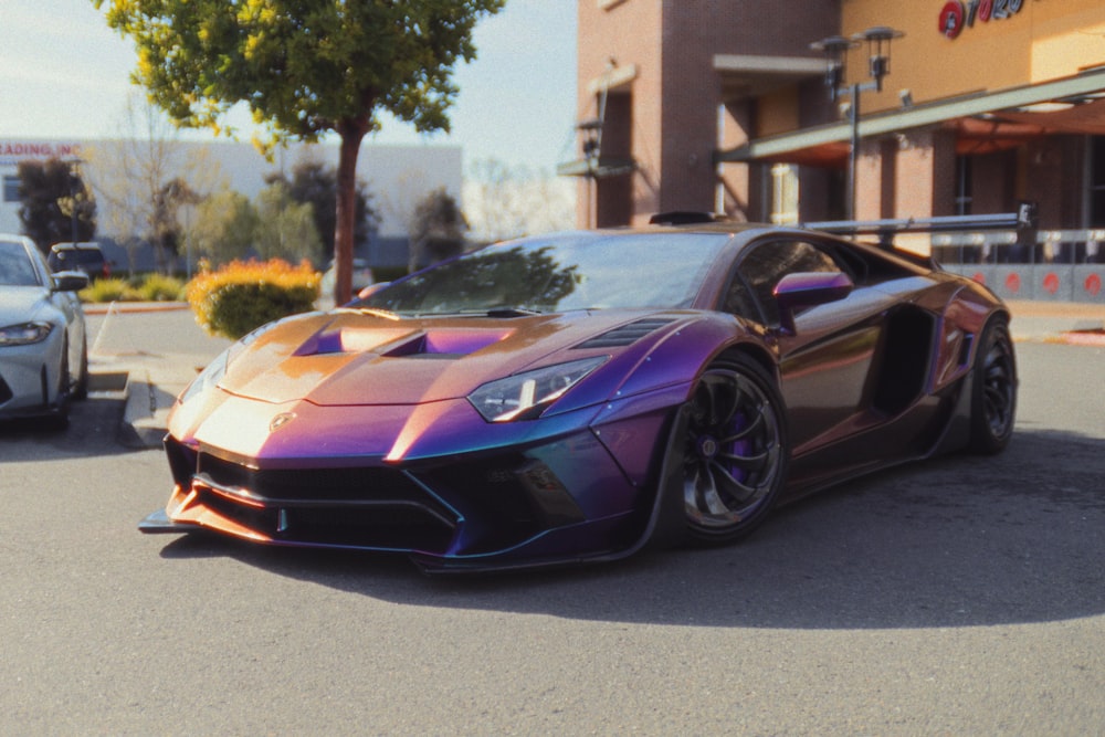 a purple and orange sports car parked in front of a building