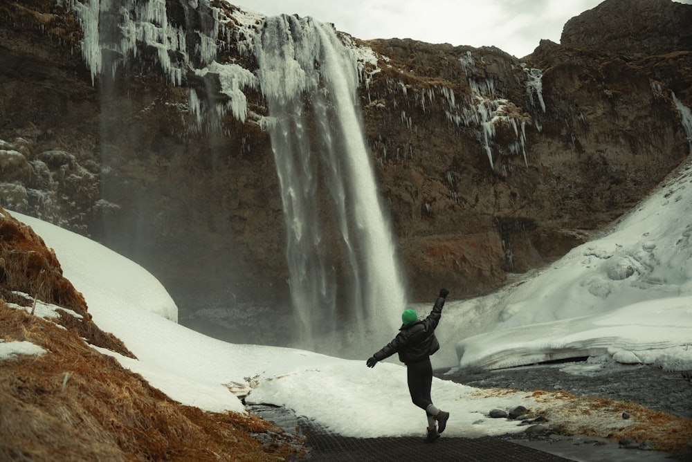 a person standing in front of a waterfall