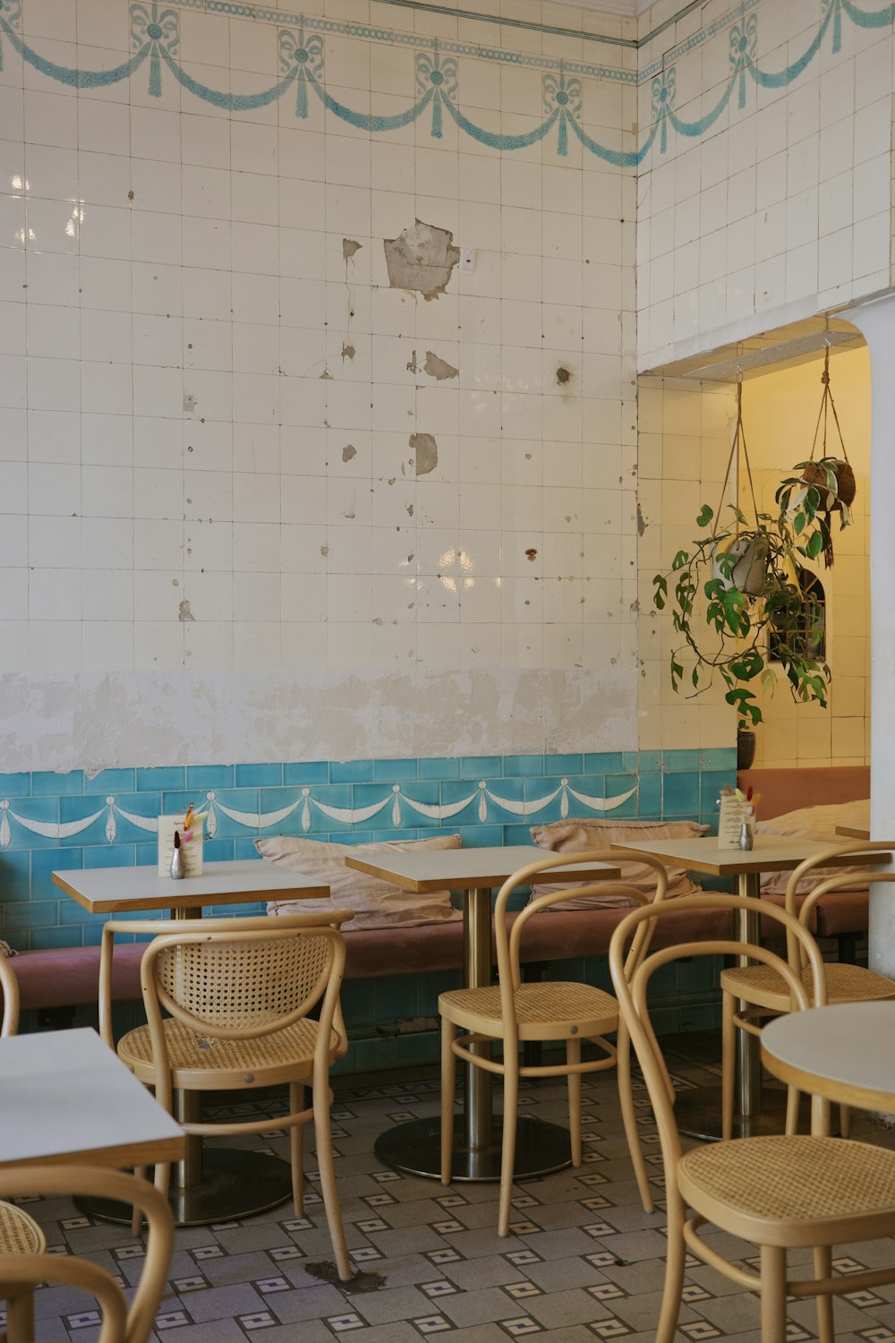 a restaurant with tables and chairs and a potted plant