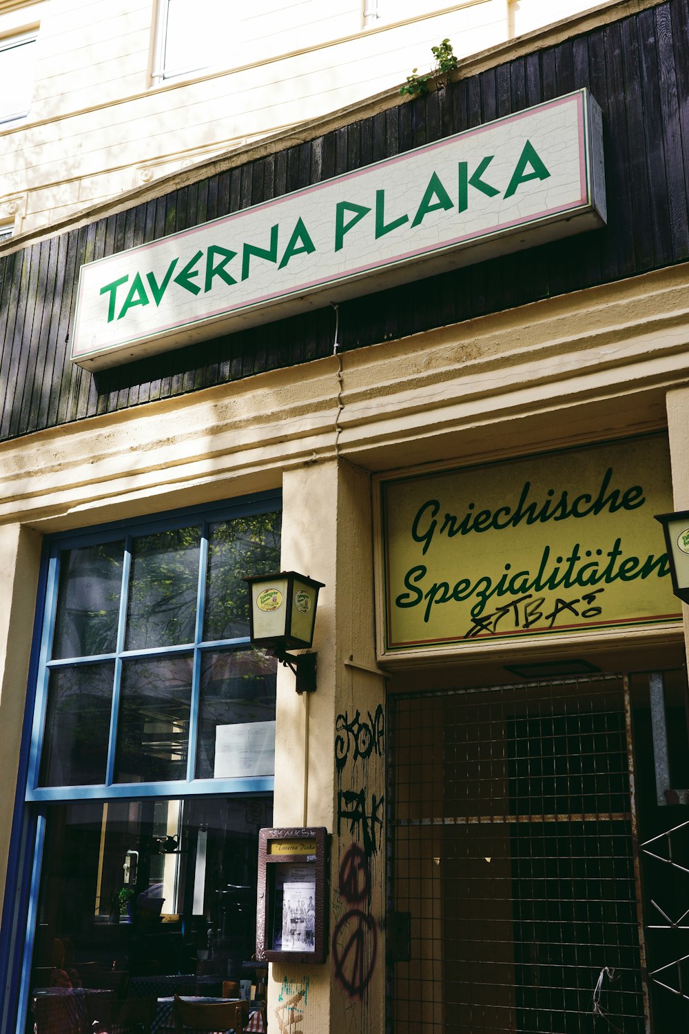 there is a sign that says tavern plaka on the front of the building