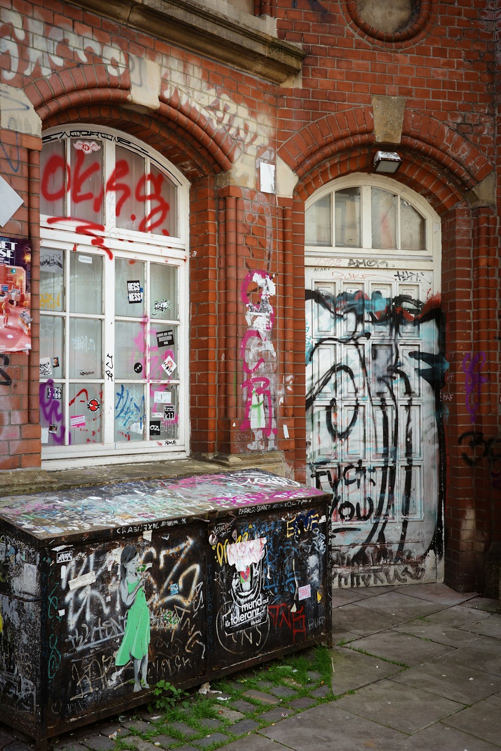 a graffiti covered trunk sitting in front of a building