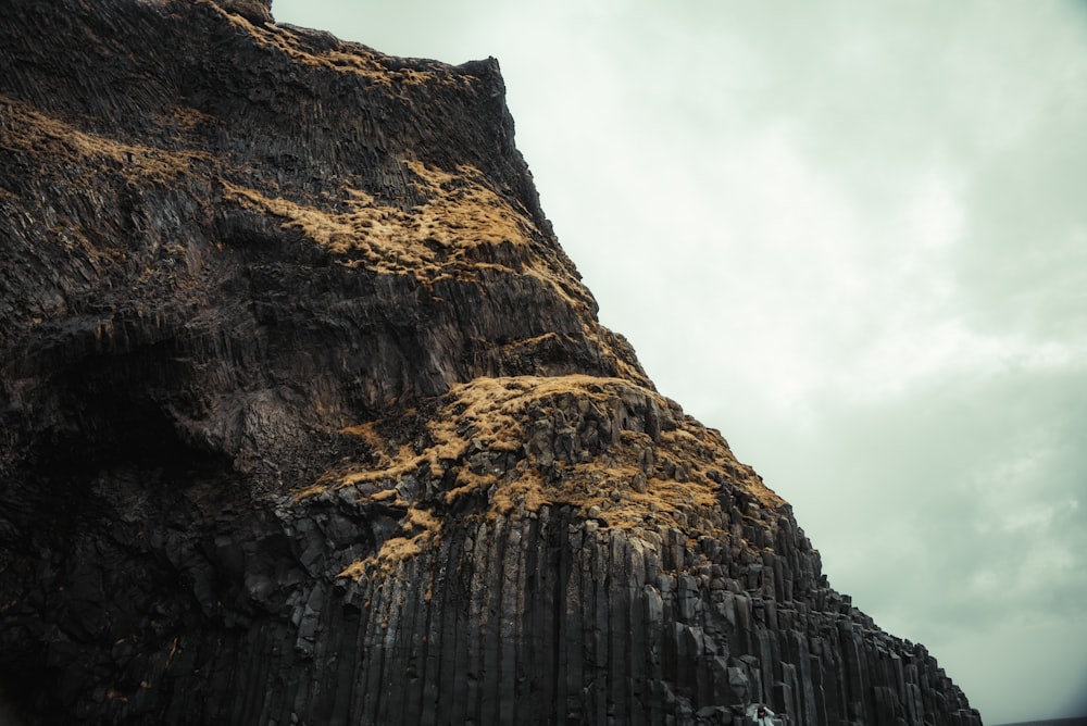 a very tall rock formation with a sky in the background