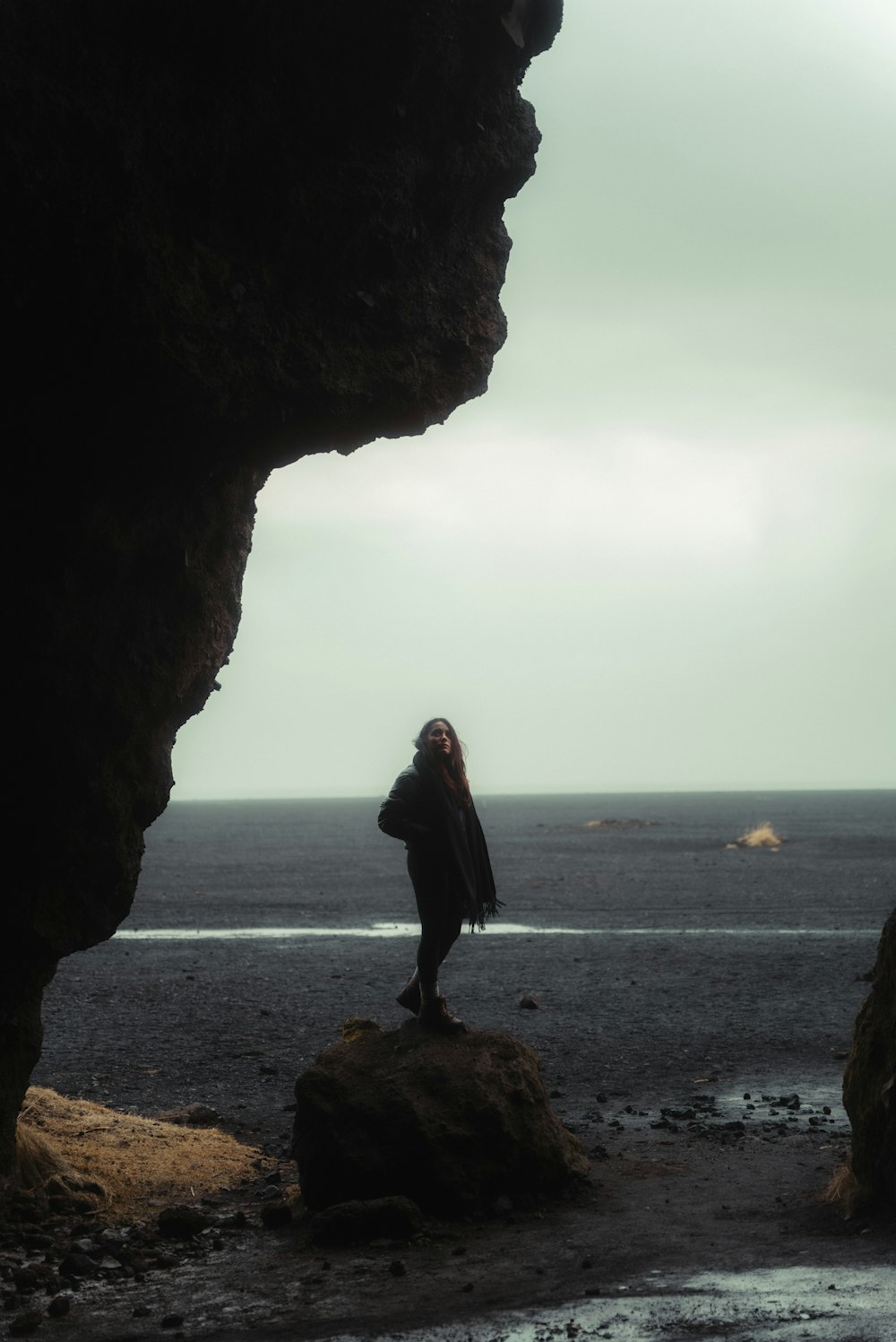 a person standing on a rock near the ocean