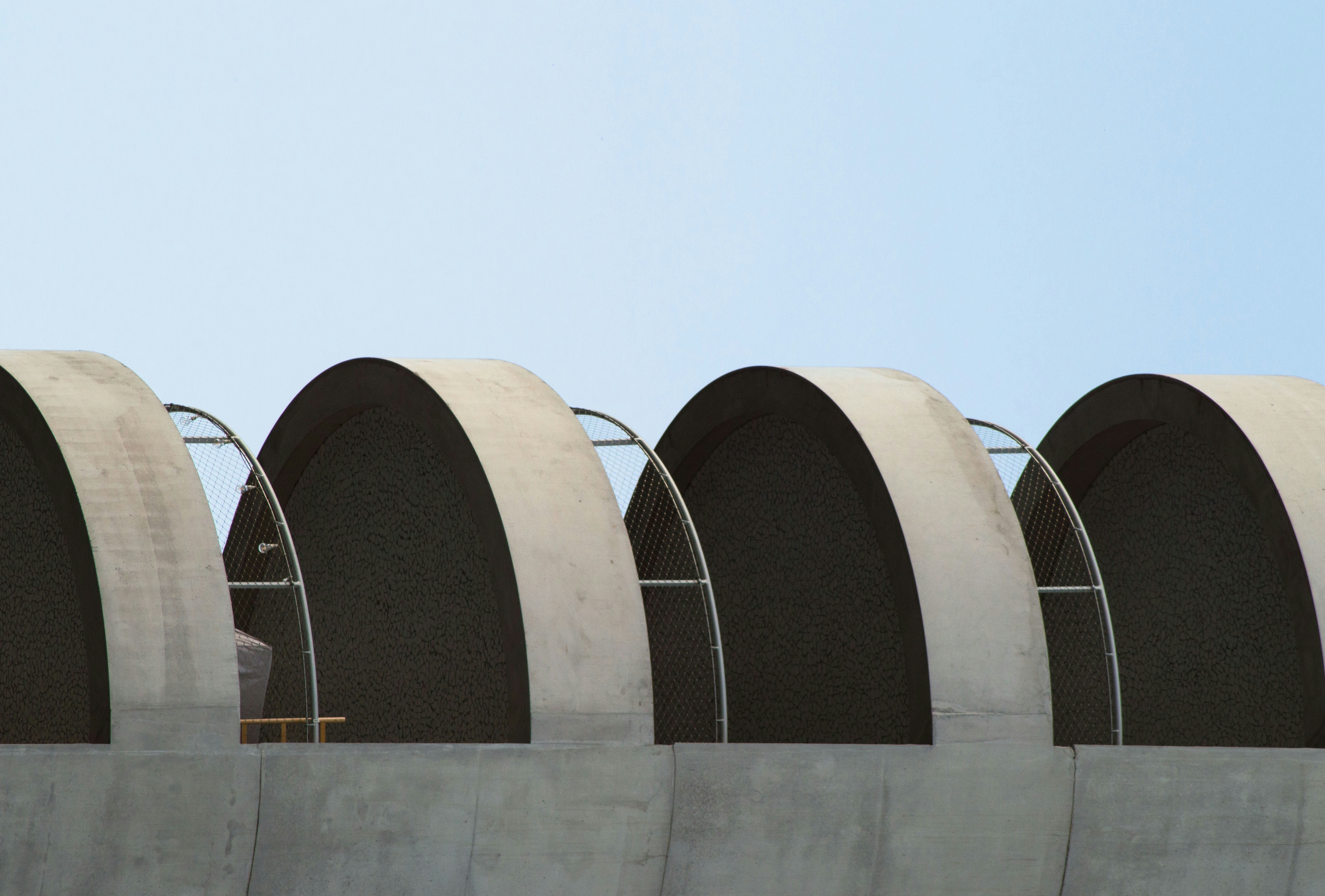 a row of round concrete structures against a blue sky