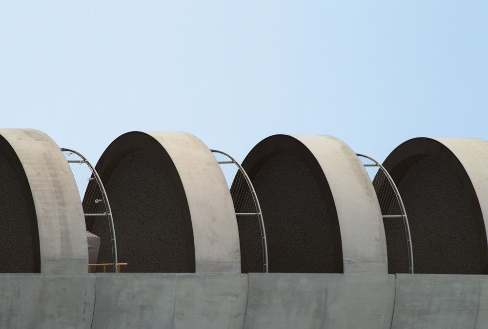 a row of round concrete structures against a blue sky
