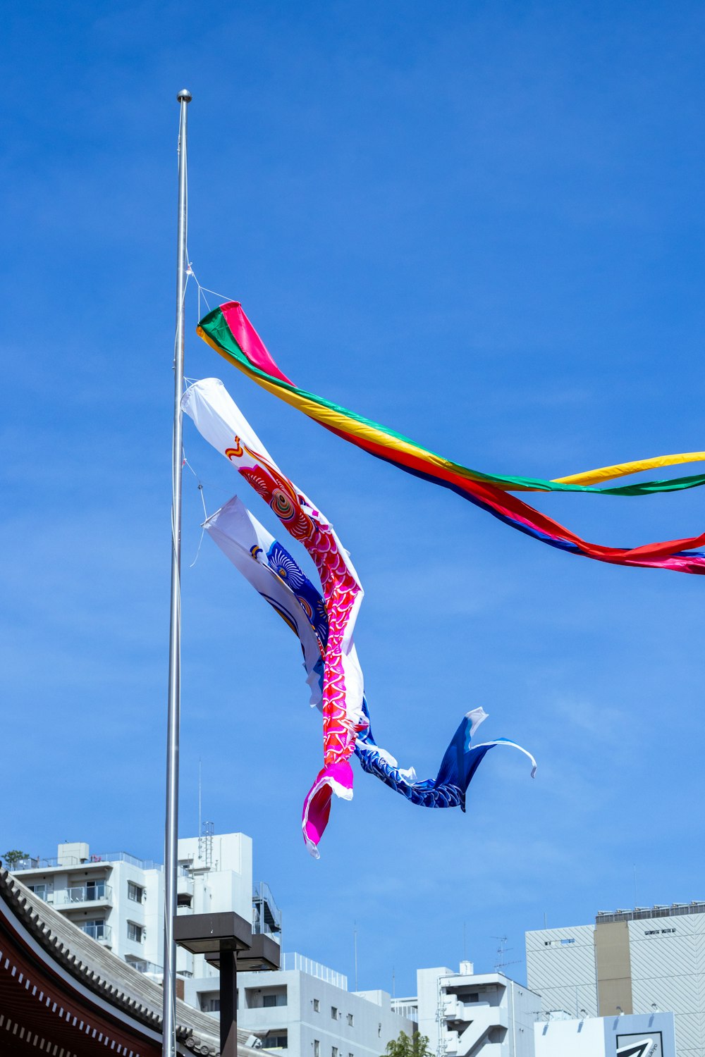 a kite flying in the air next to a tall building