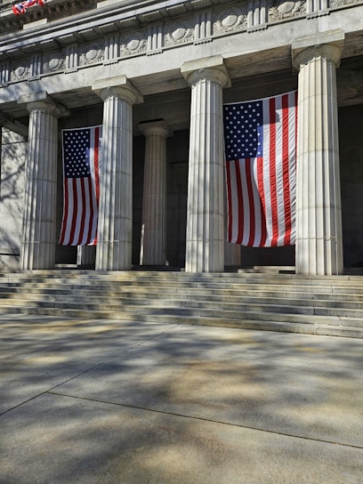 a building with columns and american flags on it
