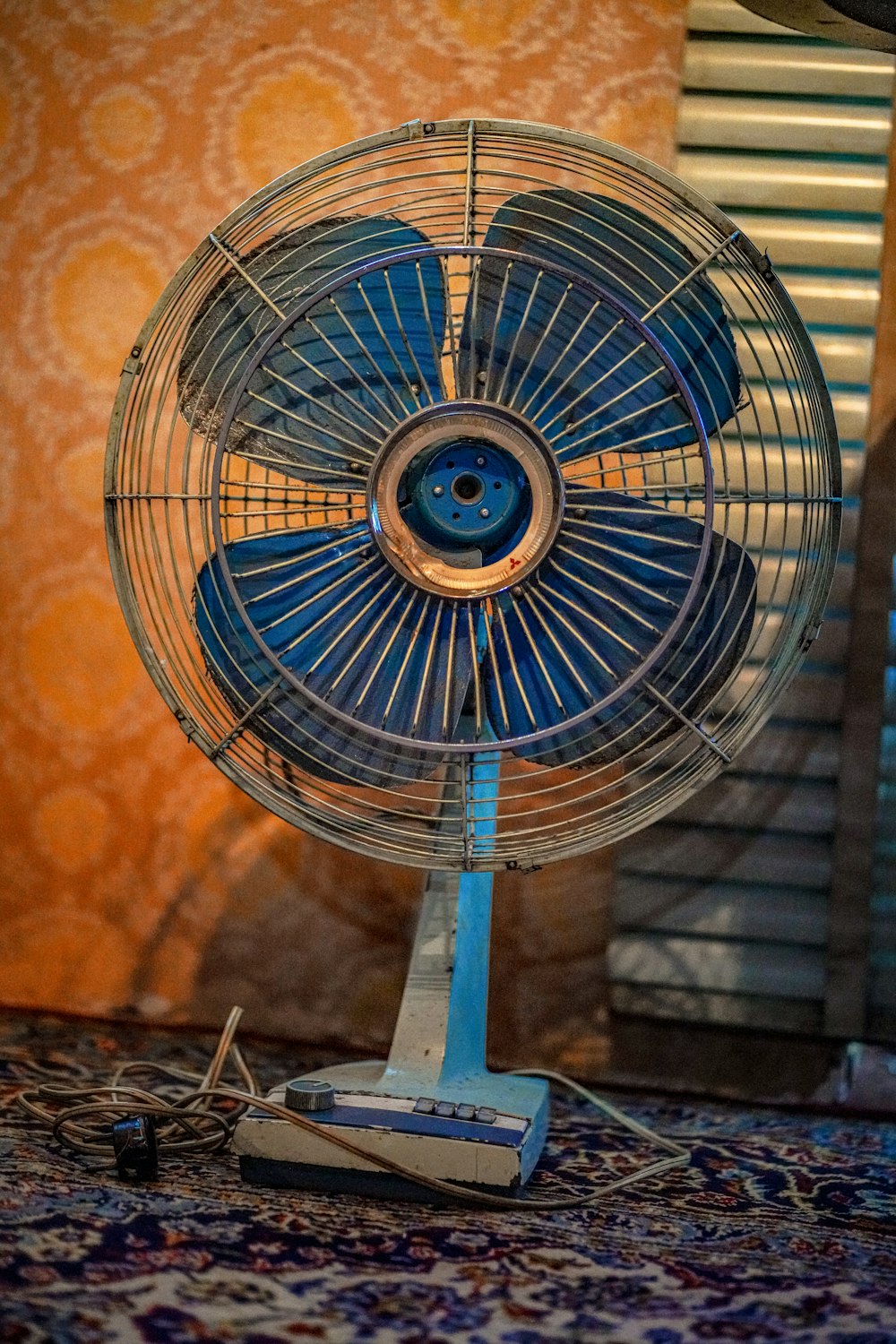 a blue fan sitting on top of a rug