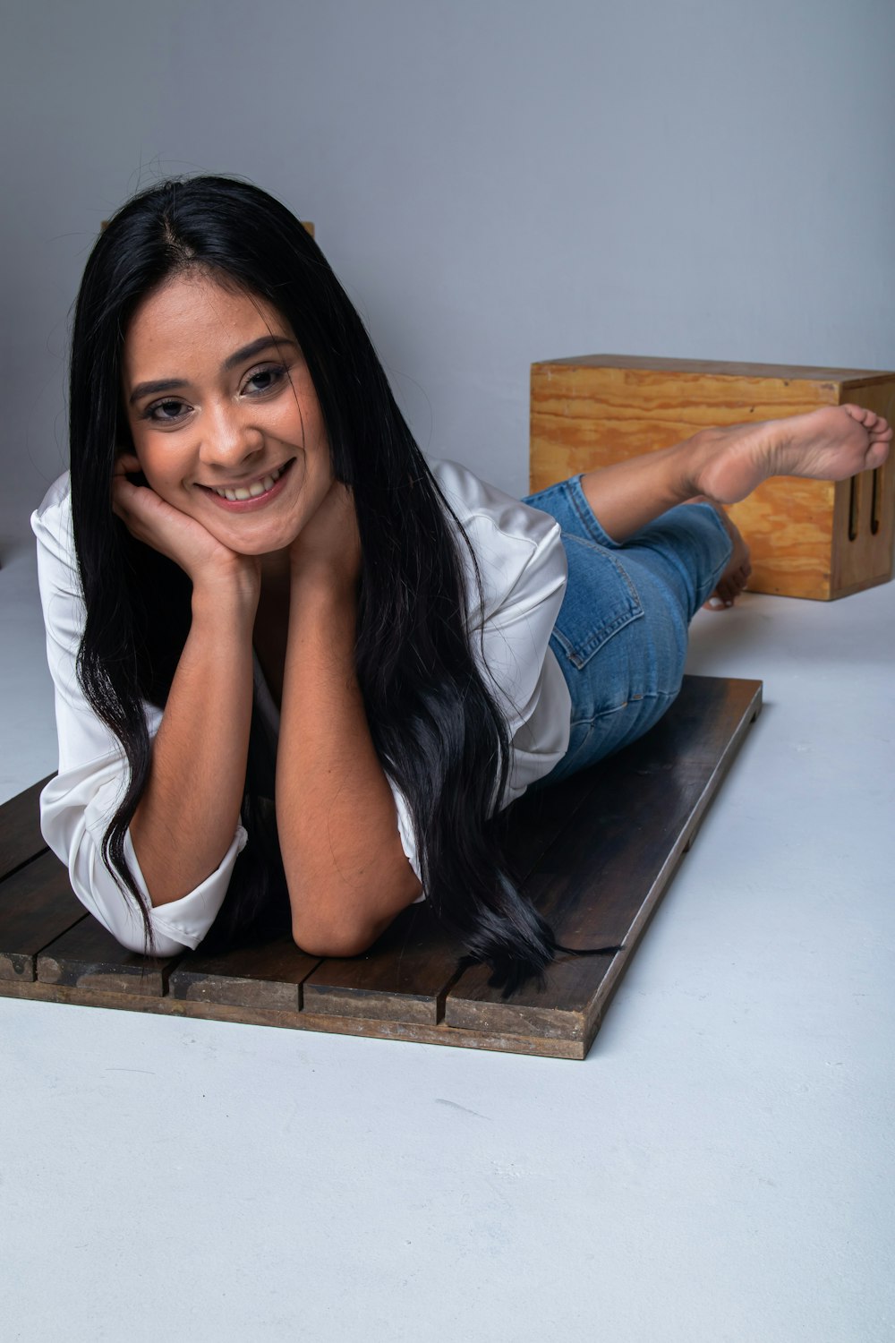 a woman laying on top of a wooden box