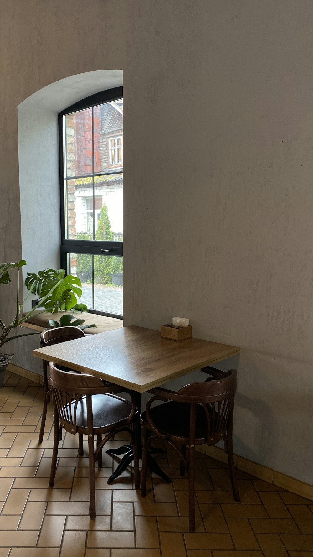 a table and chairs in a room with a large window