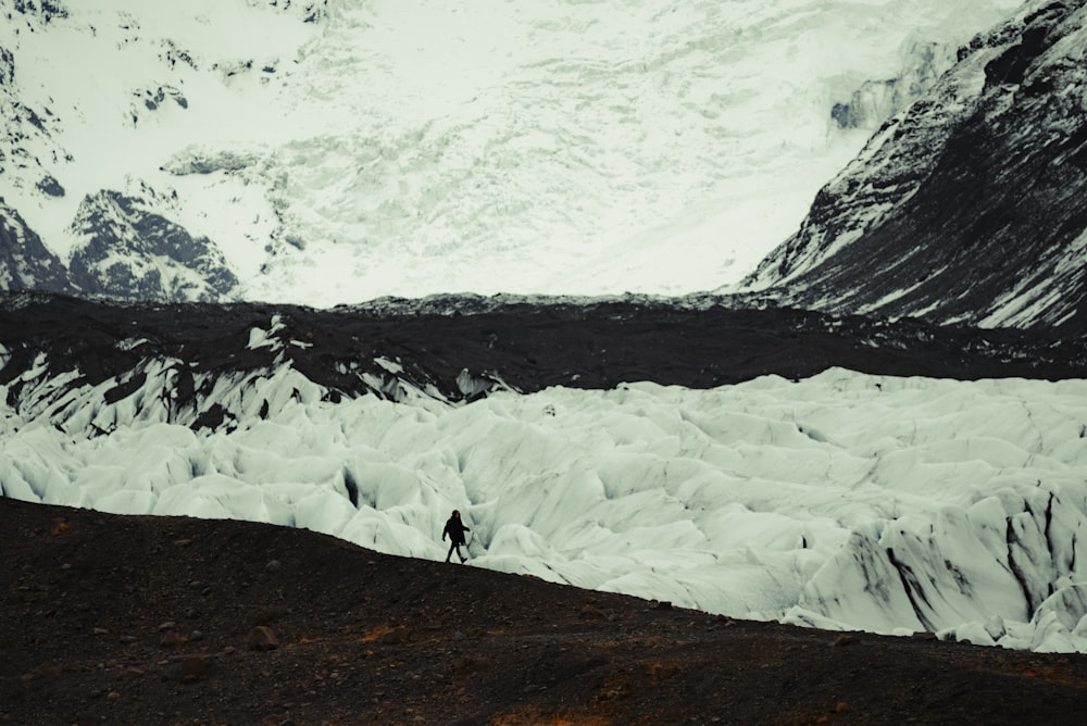 a man standing on top of a snow covered mountain