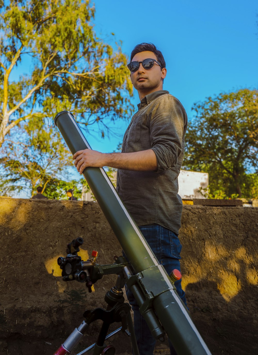 a man standing next to a large telescope